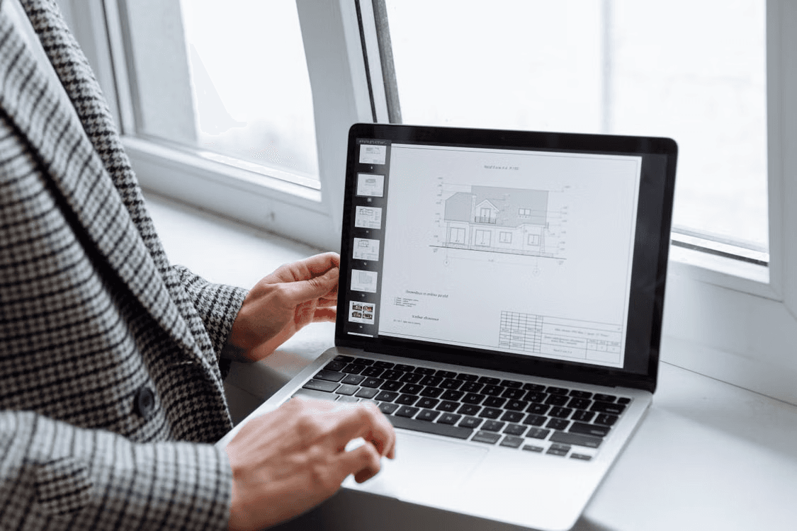 Consultant reviewing a property floor plan on a laptop